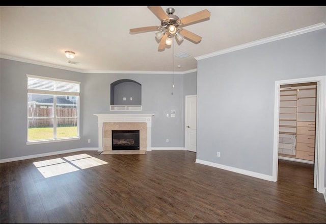 unfurnished living room with crown molding, dark hardwood / wood-style flooring, a tile fireplace, and ceiling fan