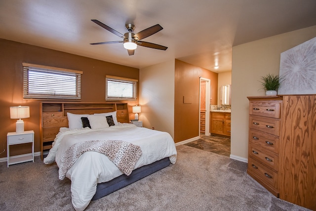 bedroom featuring dark colored carpet, ensuite bath, and ceiling fan