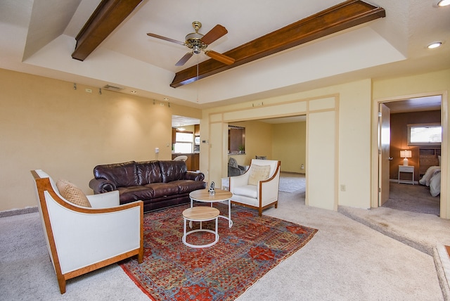 living room with ceiling fan, beamed ceiling, light colored carpet, and a healthy amount of sunlight