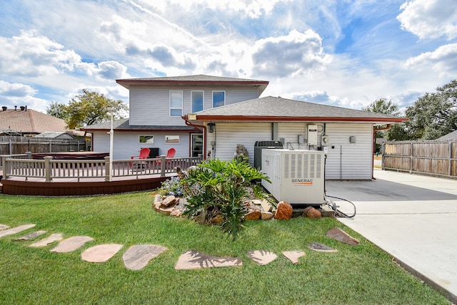 back of house featuring a lawn, a deck, and a patio