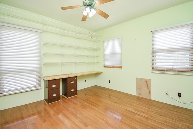 unfurnished office featuring light wood-type flooring, plenty of natural light, and ceiling fan