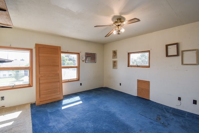 unfurnished room featuring ceiling fan and dark carpet