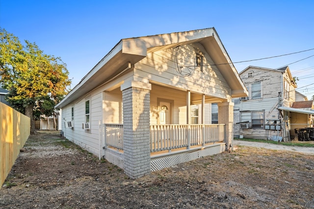 bungalow-style home featuring covered porch and cooling unit