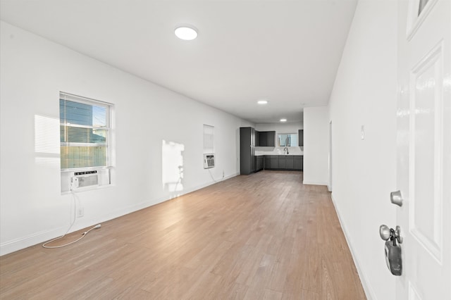 unfurnished living room featuring cooling unit, heating unit, and hardwood / wood-style floors