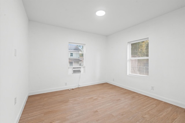 unfurnished room featuring cooling unit and light wood-type flooring