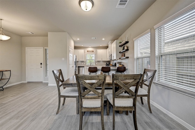 dining room featuring sink and light hardwood / wood-style floors