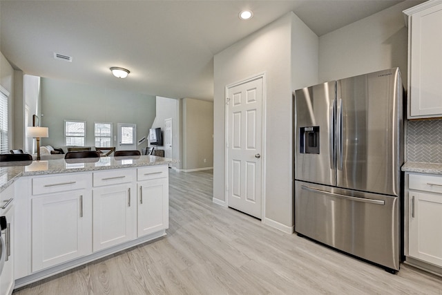 kitchen with white cabinets, light hardwood / wood-style floors, and stainless steel refrigerator with ice dispenser