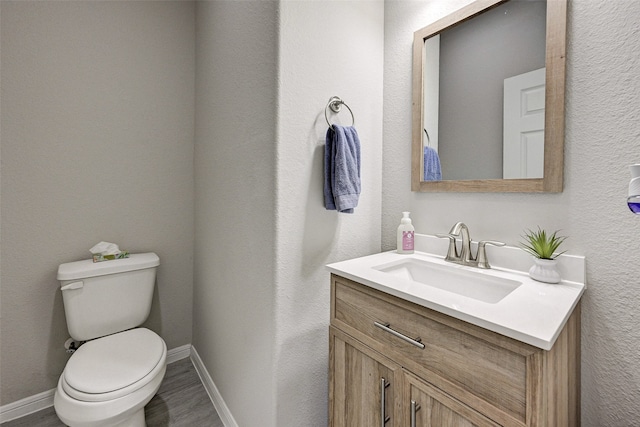 bathroom featuring vanity, toilet, and hardwood / wood-style floors