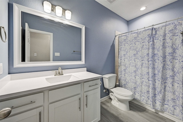 bathroom featuring vanity, toilet, a shower with shower curtain, and hardwood / wood-style floors