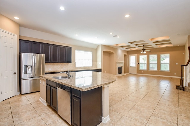 kitchen featuring sink, coffered ceiling, a kitchen island with sink, stainless steel appliances, and beam ceiling