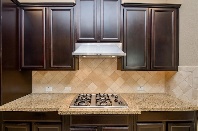 kitchen with tasteful backsplash, extractor fan, dark brown cabinets, and stainless steel gas cooktop