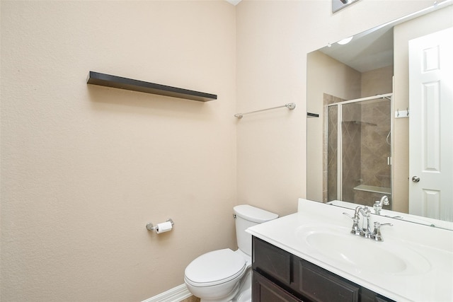 bathroom featuring toilet, vanity, and walk in shower