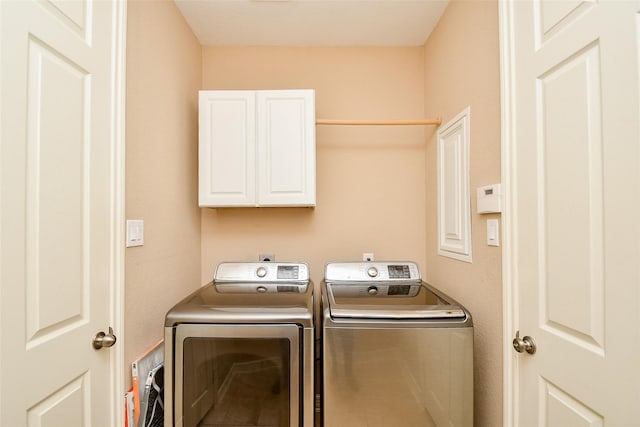 washroom with washer and clothes dryer and cabinets