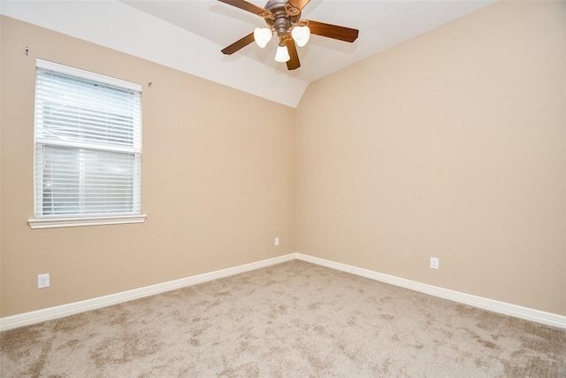 empty room with vaulted ceiling, ceiling fan, and carpet flooring