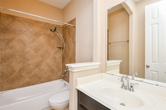 full bathroom featuring tiled shower / bath, vanity, and toilet