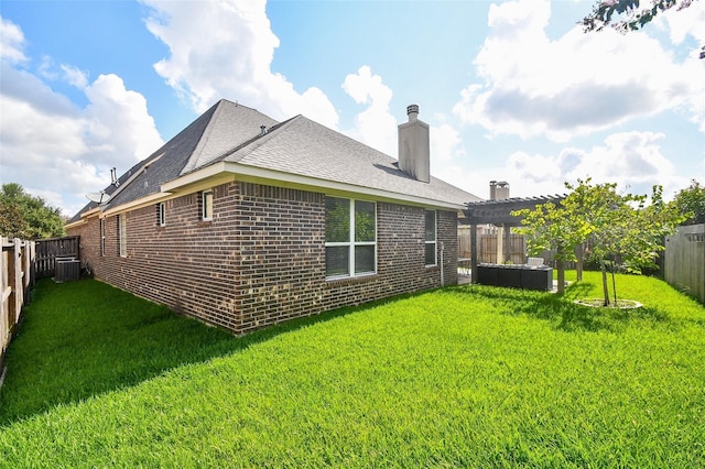 rear view of house with a pergola, a lawn, and central air condition unit