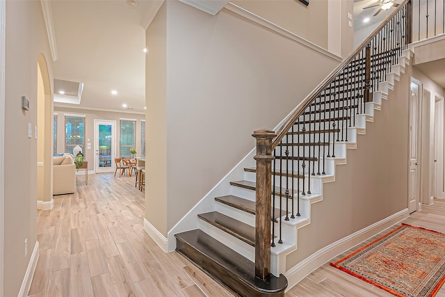 staircase featuring wood-type flooring and ornamental molding