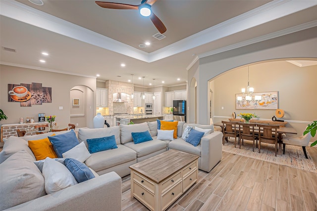 living room with ornamental molding, ceiling fan with notable chandelier, and light hardwood / wood-style floors