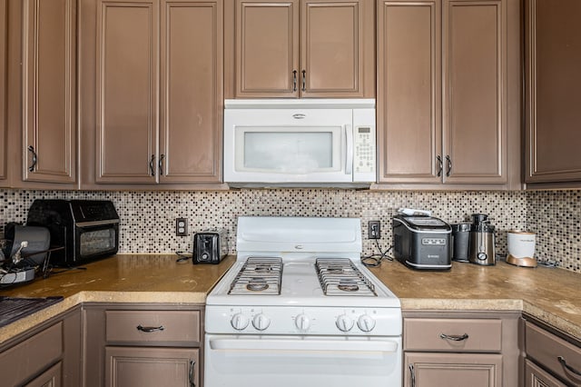 kitchen featuring decorative backsplash and white appliances