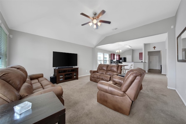 carpeted living room with ceiling fan with notable chandelier and vaulted ceiling