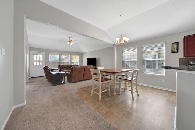 carpeted dining area with ceiling fan with notable chandelier and vaulted ceiling