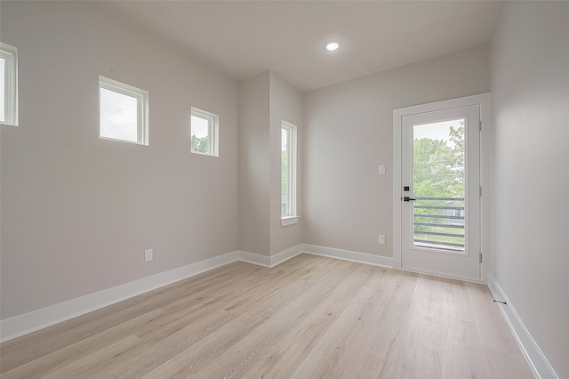 spare room with light wood-type flooring and plenty of natural light