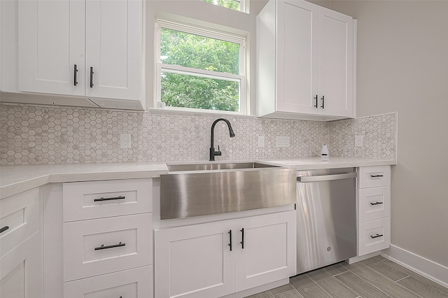 kitchen with sink, dishwasher, white cabinets, and decorative backsplash