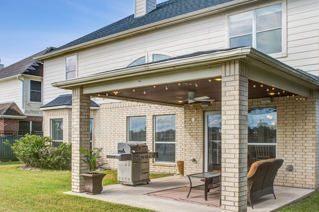 rear view of house with ceiling fan, a patio, and a yard