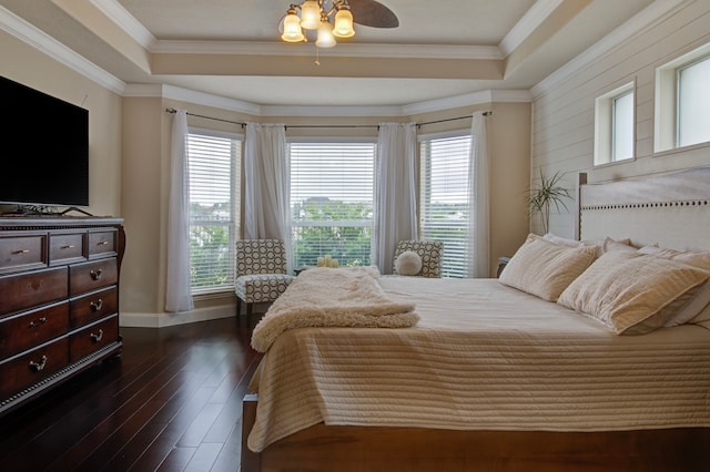 bedroom featuring dark wood-type flooring, crown molding, and a tray ceiling