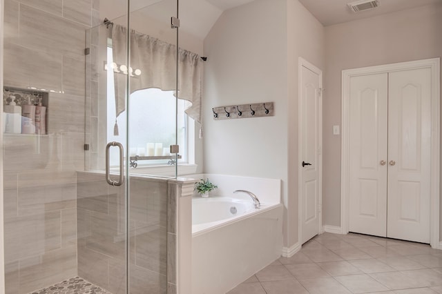 bathroom with tile patterned flooring, separate shower and tub, and vaulted ceiling