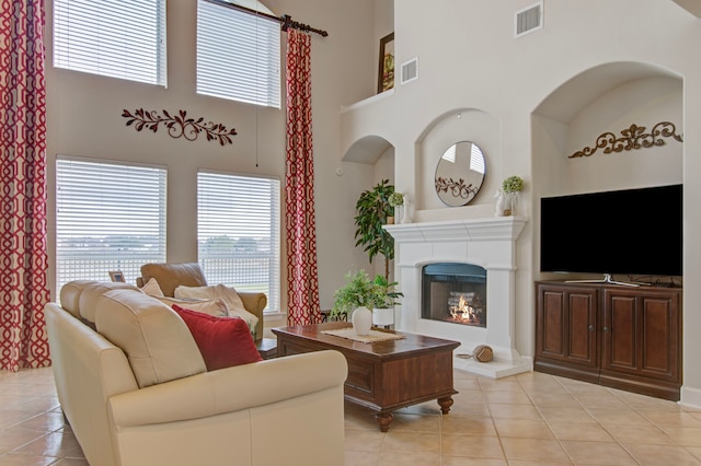 living room with a towering ceiling and light tile patterned floors