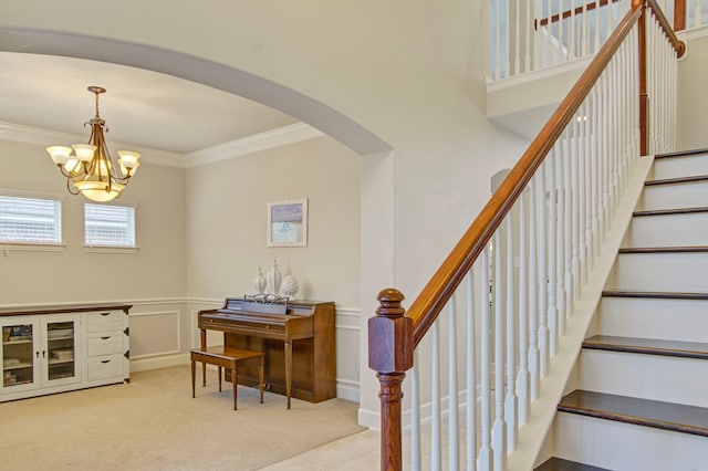 stairway with carpet, an inviting chandelier, and crown molding