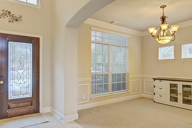 entryway with a notable chandelier, light carpet, and ornamental molding