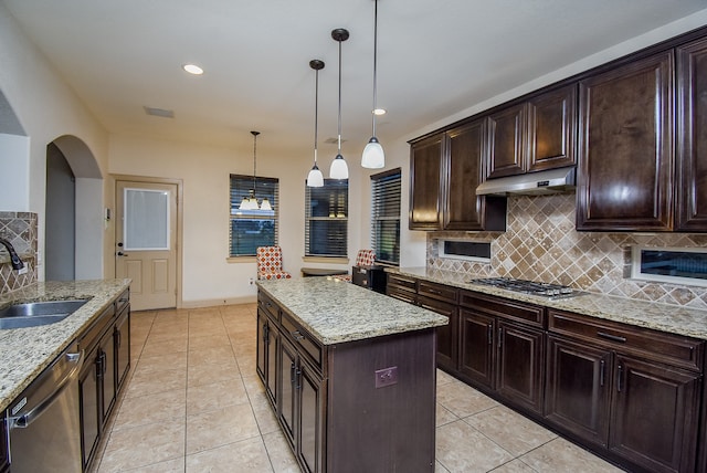 kitchen with stainless steel appliances, sink, a center island, dark brown cabinetry, and pendant lighting