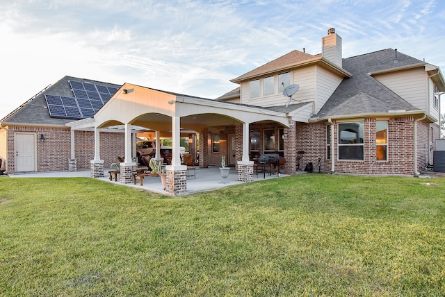 rear view of property featuring a yard and a patio