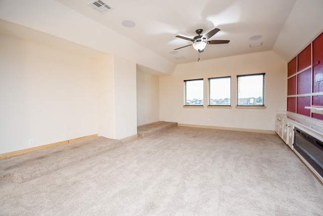 unfurnished living room featuring ceiling fan, light colored carpet, and vaulted ceiling