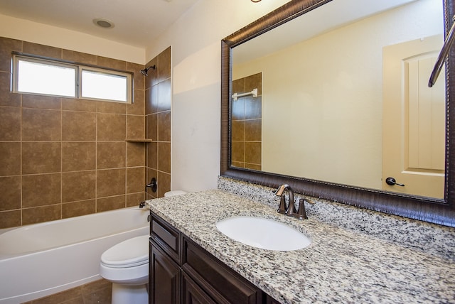 full bathroom featuring toilet, tiled shower / bath combo, vanity, and tile patterned flooring