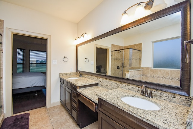 bathroom with a shower with door, vanity, and tile patterned flooring