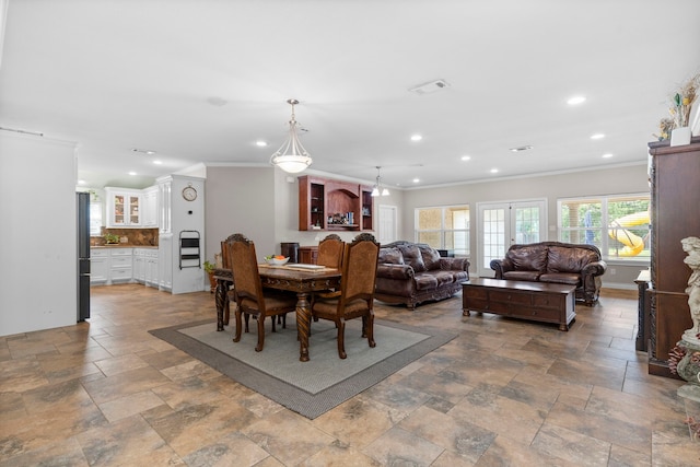 dining area with crown molding and french doors