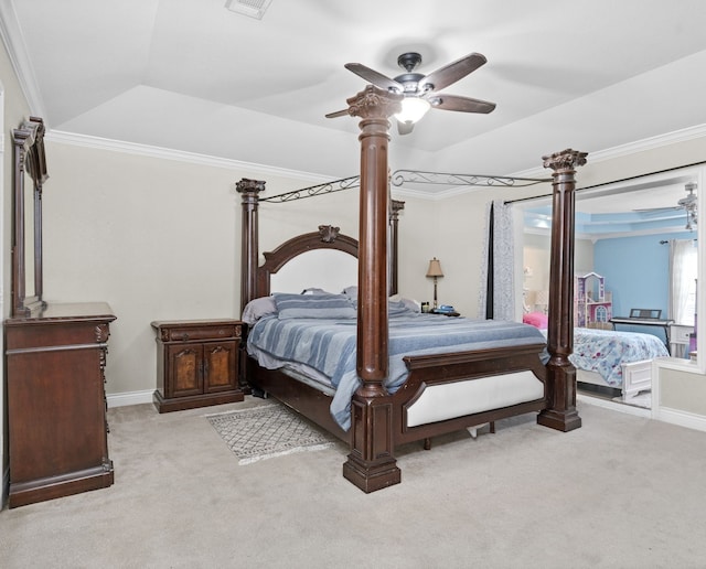 carpeted bedroom with ornamental molding, a tray ceiling, and ceiling fan