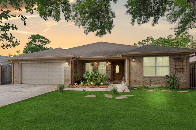 view of front of property with a garage and a lawn