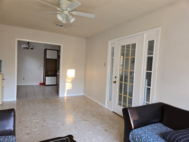 living room with a textured ceiling and ceiling fan