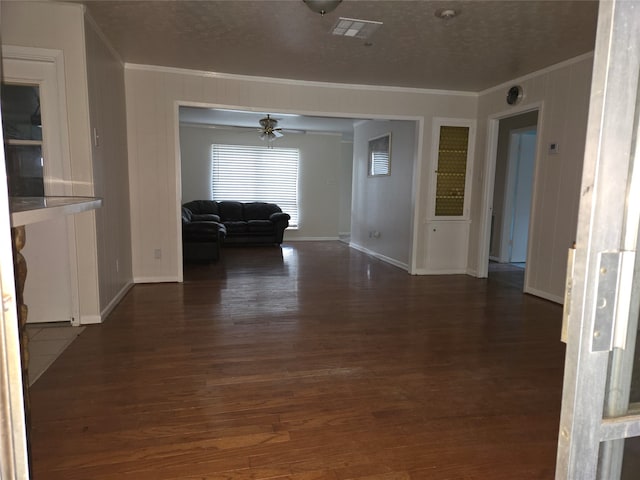 interior space with ornamental molding, dark hardwood / wood-style floors, and a textured ceiling