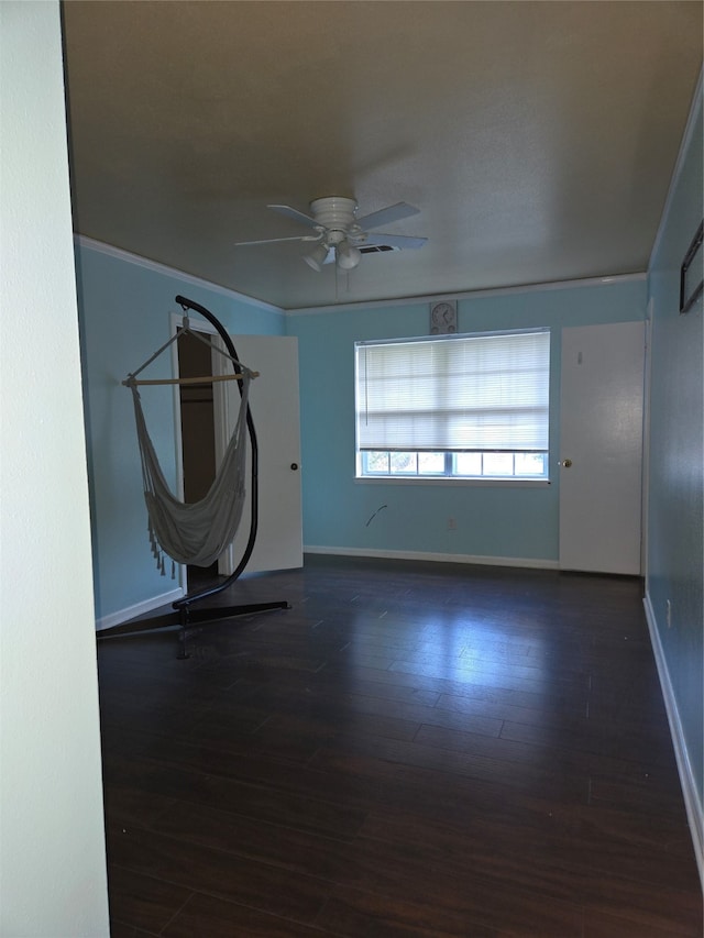 spare room featuring ceiling fan, crown molding, and dark hardwood / wood-style flooring