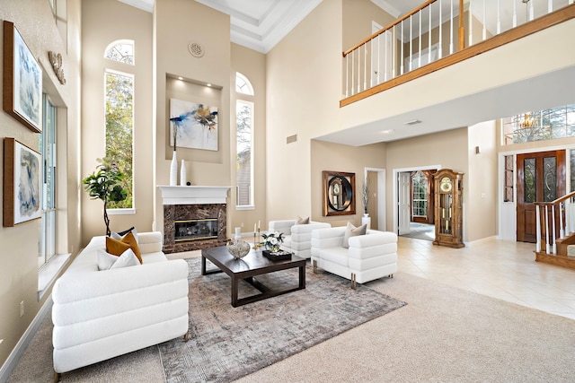 living room with a towering ceiling, crown molding, light carpet, and plenty of natural light