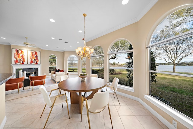 dining room featuring a water view, crown molding, a healthy amount of sunlight, and light tile patterned floors