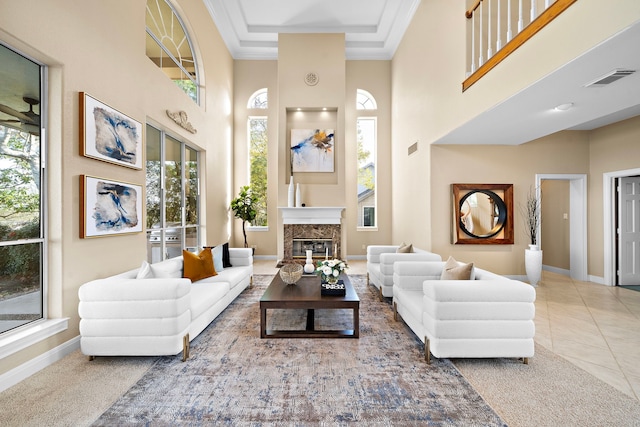 living room with a healthy amount of sunlight, a towering ceiling, and ornamental molding