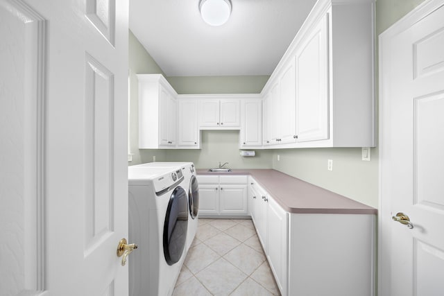 clothes washing area featuring cabinets, sink, washer and clothes dryer, and light tile patterned floors