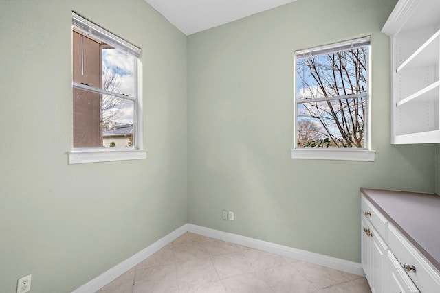 spare room with baseboards and plenty of natural light