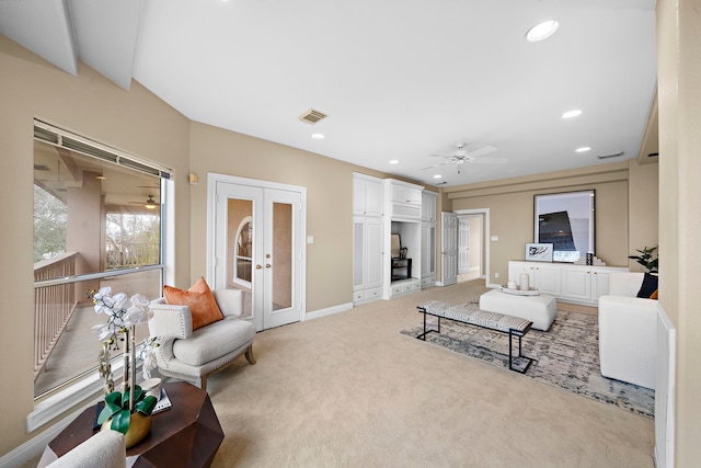 living area featuring visible vents, light carpet, baseboards, ceiling fan, and french doors